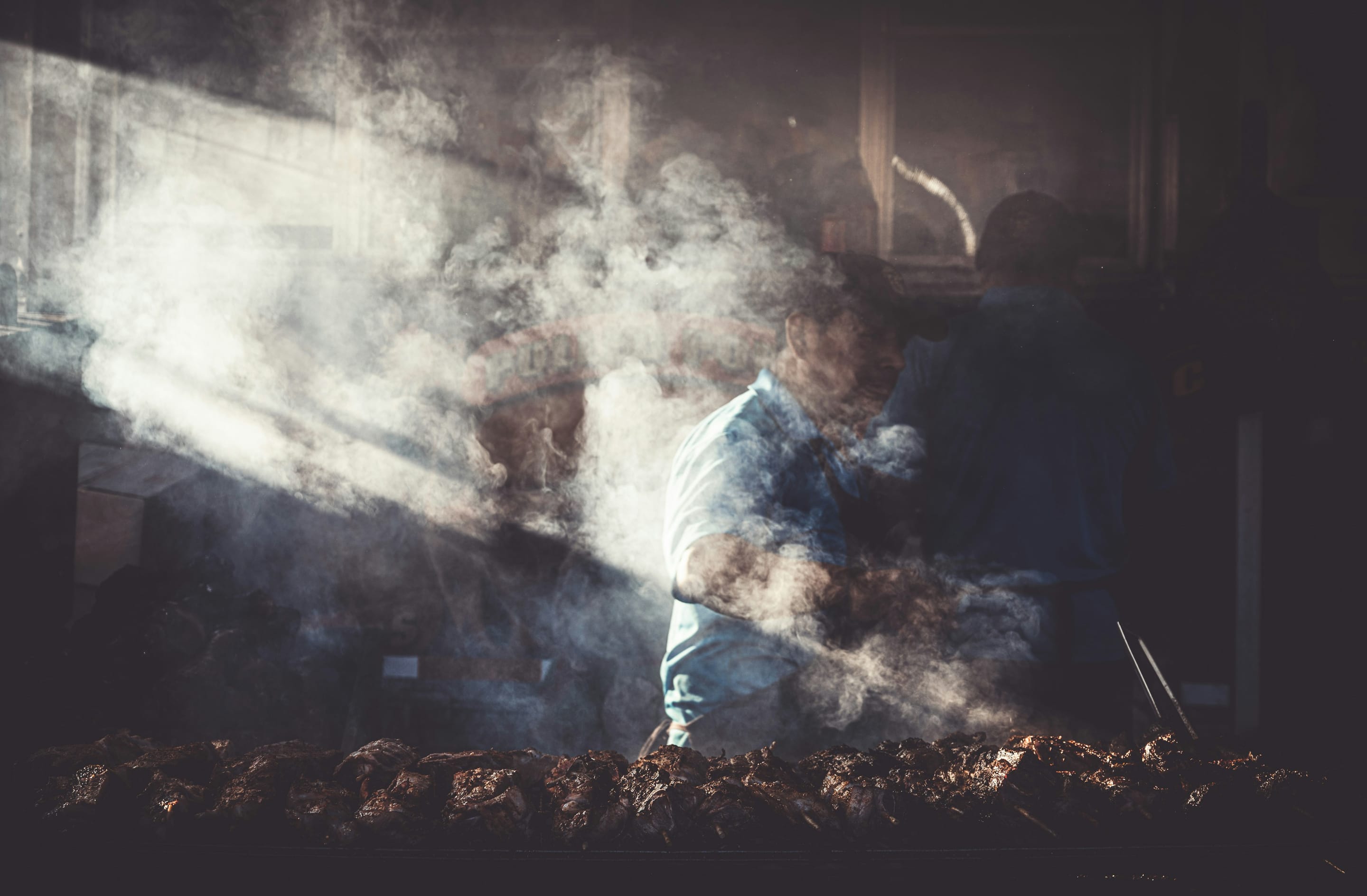 Smoke and shafts of light over a market grill