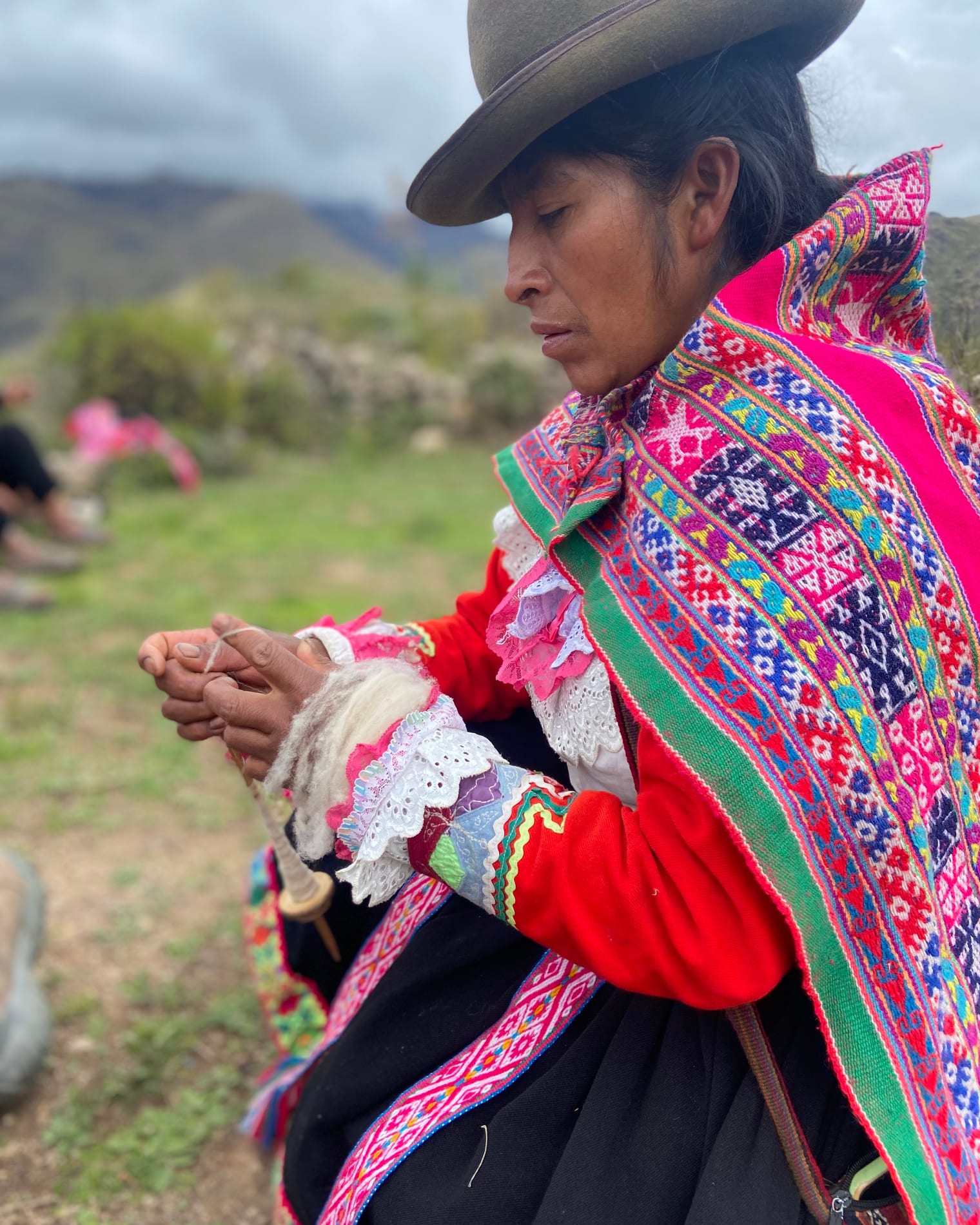 A Lamay community member spinning wool in the fields
